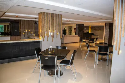 a restaurant with tables and chairs and a bar at HOTEL MANZUR in Barranquilla