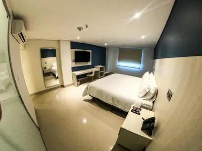 a hotel room with a bed and a desk at HOTEL MANZUR in Barranquilla