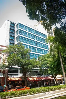 a tall building with a car parked in front of it at HOTEL MANZUR in Barranquilla