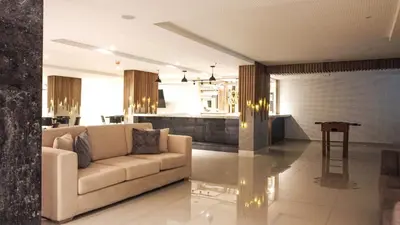 a living room with a couch and a kitchen at HOTEL MANZUR in Barranquilla