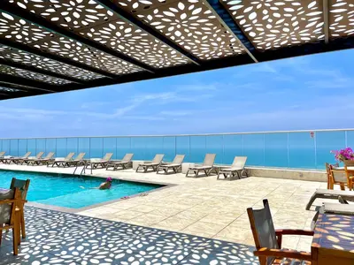 a pool with chairs and a person in the water at by Calamari Homes - Palmetto Beach 2504 Bocagrande in Cartagena de Indias