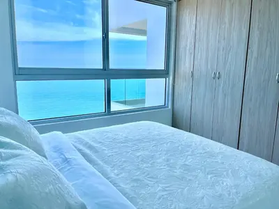 a bedroom with a bed and a large window at by Calamari Homes - Palmetto Beach 2504 Bocagrande in Cartagena de Indias