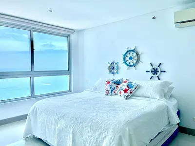 a blue bedroom with a bed and a window at by Calamari Homes - Palmetto Beach 2504 Bocagrande in Cartagena de Indias