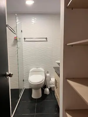 a bathroom with a toilet and a glass shower at Hermoso apartamento en Coveñas con piscina in Coveñitas