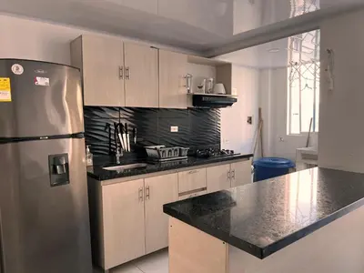 a kitchen with a stainless steel refrigerator and cabinets at Hermoso apartamento en Coveñas con piscina in Coveñitas