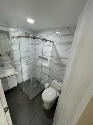 a bathroom with a toilet and a glass shower at Hermoso Apartamento vista al mar El Laguito in Cartagena de Indias