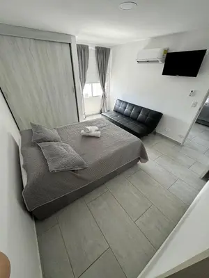 a small bedroom with a bed and a couch at Hermoso Apartamento vista al mar El Laguito in Cartagena de Indias