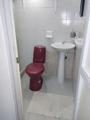 a bathroom with a red toilet and a sink at Habitación privada en Bocagrande in Cartagena de Indias