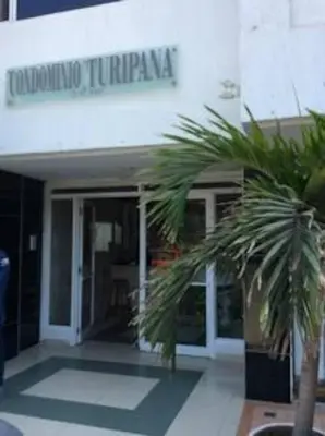 a building with a palm tree in front of it at Habitación privada en Bocagrande in Cartagena de Indias