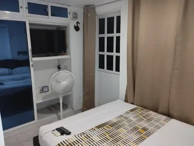 a bedroom with a bed with a fan and a window at Habitación privada en Bocagrande in Cartagena de Indias
