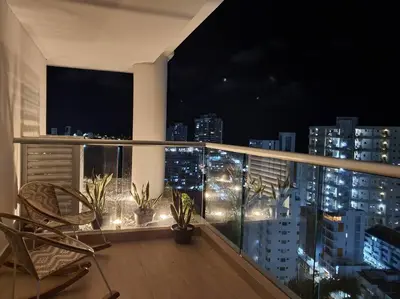 a balcony with a view of a city at night at Apartamento con vista al mar y al centro de Cartagena in Cartagena de Indias