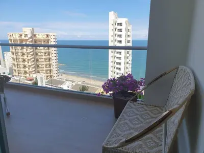 a balcony with a chair and a view of the ocean at Apartamento con vista al mar y al centro de Cartagena in Cartagena de Indias