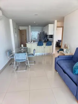 a living room with a blue couch and a table at Apartamento con vista al mar y al centro de Cartagena in Cartagena de Indias