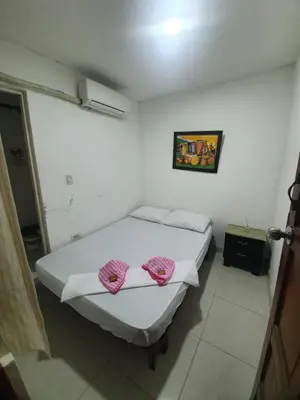 a bedroom with a bed with pink pillows on it at CASA ZOÉ in Cartagena de Indias