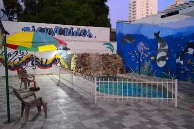 a building with a swimming pool and an umbrella at CASA ZOÉ in Cartagena de Indias