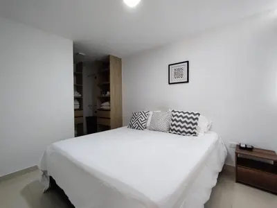 a white bedroom with a large white bed with pillows at Hermoso y acogedor apartamento al norte de Barranquilla sector BUENAVISTA in Barranquilla