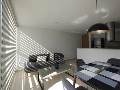 a living room with a glass table and chairs at Hermoso y acogedor apartamento al norte de Barranquilla sector BUENAVISTA in Barranquilla