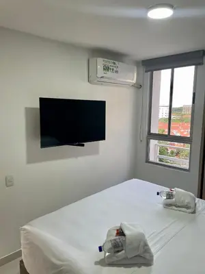 a bedroom with a bed with a tv on the wall at Moderno apartamento al norte de Barranquilla in Barranquilla