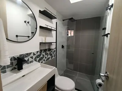 a bathroom with a shower and a sink and a mirror at Moderno apartamento al norte de Barranquilla in Barranquilla