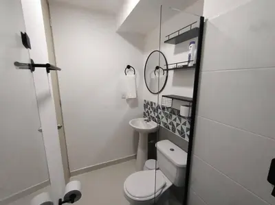 a white bathroom with a toilet and a mirror at Moderno apartamento al norte de Barranquilla in Barranquilla