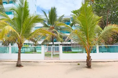 two palm trees on the beach in front of a building at Magico Apartamento Frente al Mar 3 Habitaciones C11A in Coveñas