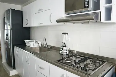 a kitchen with a stove top and a refrigerator at Magico Apartamento Frente al Mar 3 Habitaciones C11A in Coveñas