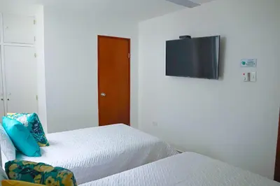 a bedroom with a bed with a television on the wall at Magico Apartamento Frente al Mar 3 Habitaciones C11A in Coveñas