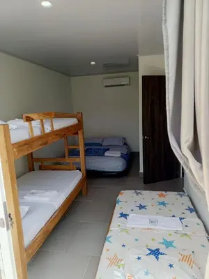 a small room with two bunk beds and a door at casa de vacaciones tierra bomba cartagena de indias in Tierra Bomba