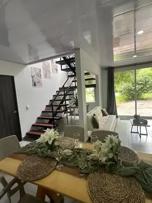 a dining room with a table and a spiral staircase at casa de vacaciones tierra bomba cartagena de indias in Tierra Bomba