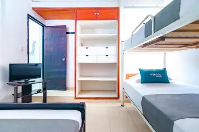 a bedroom with two beds and a bunk room with a staircase at Ayenda Casa Amarilla in Santa Marta