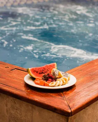 a plate of food on a table next to a pool at Hb1 Triple Room With Air Conditioning And WIFI in Cartagena de Indias