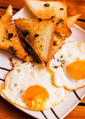 a plate of eggs and toast and bread on a table at Hb1 Triple Room With Air Conditioning And WIFI in Cartagena de Indias