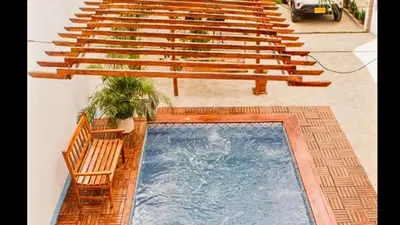 a row of benches and a swimming pool in a building at Hb1 Triple Room With Air Conditioning And WIFI in Cartagena de Indias