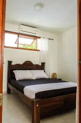 a bedroom with a wooden bed in a room at Hb2 Triple Room with shared bathroom in Cartagena de Indias