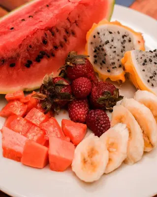 a white plate with fruit on a table at Hb2 Triple Room with shared bathroom in Cartagena de Indias