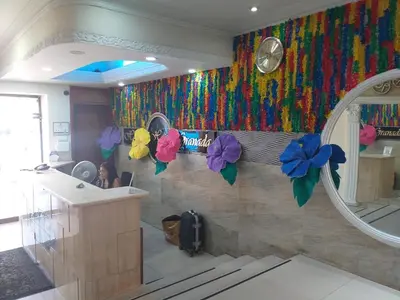 a bathroom with a mirror and flowers on the wall at Hotel Granada Inn in Barranquilla
