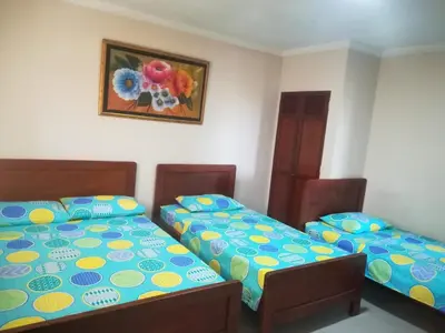 a bedroom with two beds and a picture on the wall at Hotel Granada Inn in Barranquilla