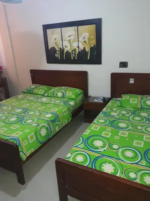 two beds sitting next to each other in a bedroom at Hotel Granada Inn in Barranquilla