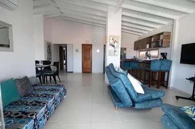 a living room with blue couches and a kitchen at Casa Bita Morales CASA 201 in Cartagena de Indias