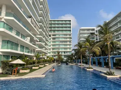 a person in a swimming pool in front of a building at Apartamento de lujo Morros ULTRA con vista y acceso directo al mar , Cartagena de Indias in Cartagena de Indias
