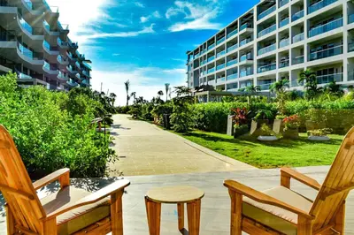 a patio with two chairs and a table and a building at Hermoso y con acceso directo a la playa! in Cartagena de Indias