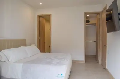 a bedroom with a white bed in a room at Hermoso y con acceso directo a la playa! in Cartagena de Indias