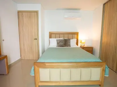 a bedroom with a large bed with a wooden frame at Acogedor Marbella ideal familias mínimo 2 días in Cartagena de Indias