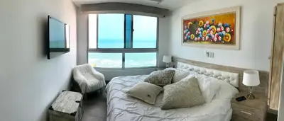 a bedroom with a white bed and a window at Apartamento Fantástico in Cartagena de Indias