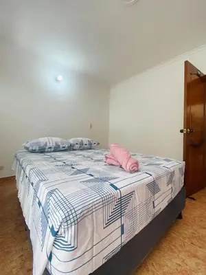 a bedroom with a bed with a pink pillow on it at Cartagena Kings Hostel in Cartagena de Indias