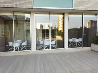 a group of chairs and tables in a building with windows at Distrito 90 in Barranquilla