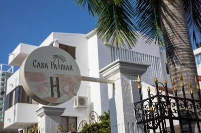 a sign in front of a building with a palm tree at Casa Palmar Cartagena in Cartagena de Indias