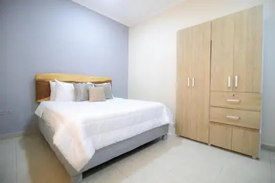 a bedroom with a large bed and a wooden cabinet at Casa Palmar Cartagena in Cartagena de Indias