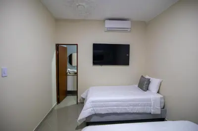a hotel room with two beds and a flat screen tv at Casa Palmar Cartagena in Cartagena de Indias