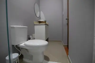 a bathroom with a white toilet and a mirror at Casa Palmar Cartagena in Cartagena de Indias